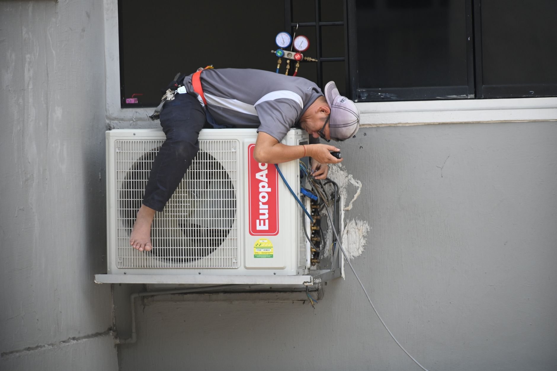 A technician repairing an outdoor air conditioning unit.